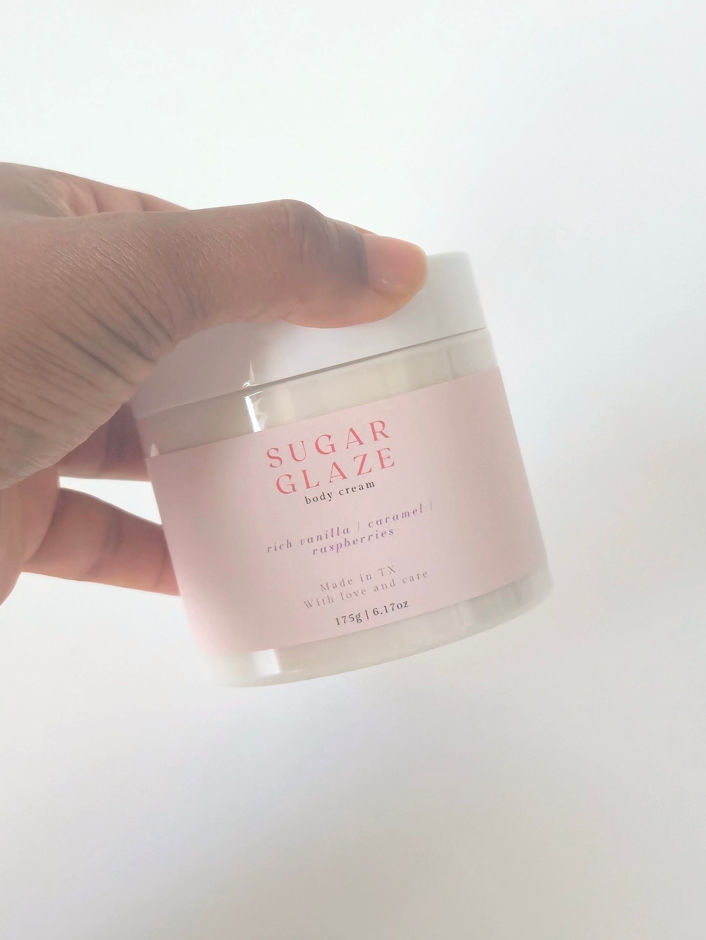 Sugar Glaze body cream in a 175g plastic jar. Rich, sweet-scented cream with notes of caramel, vanilla, and raspberry. Dessert-inspired body care.