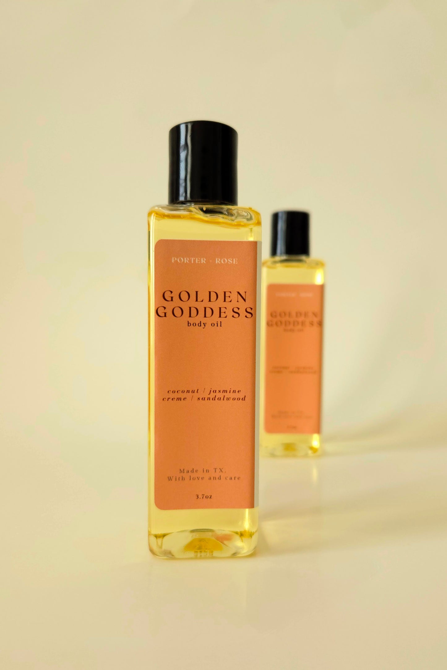 Golden Goddess body oil in a sleek rectangular bottle, styled with coconut, pistachio, and amber tones to reflect its warm, sweet scent.