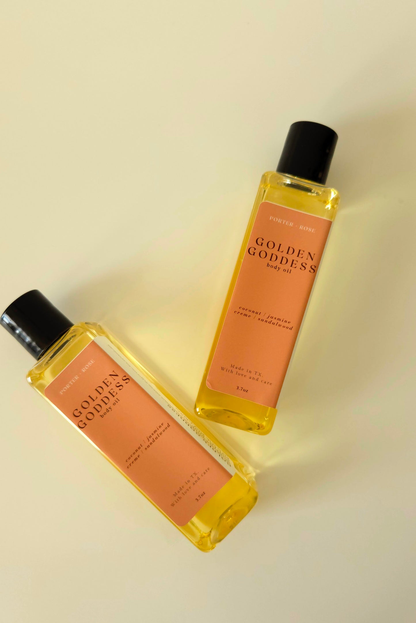 Golden Goddess body oil in a sleek rectangular bottle, styled with coconut, pistachio, and amber tones to reflect its warm, sweet scent.