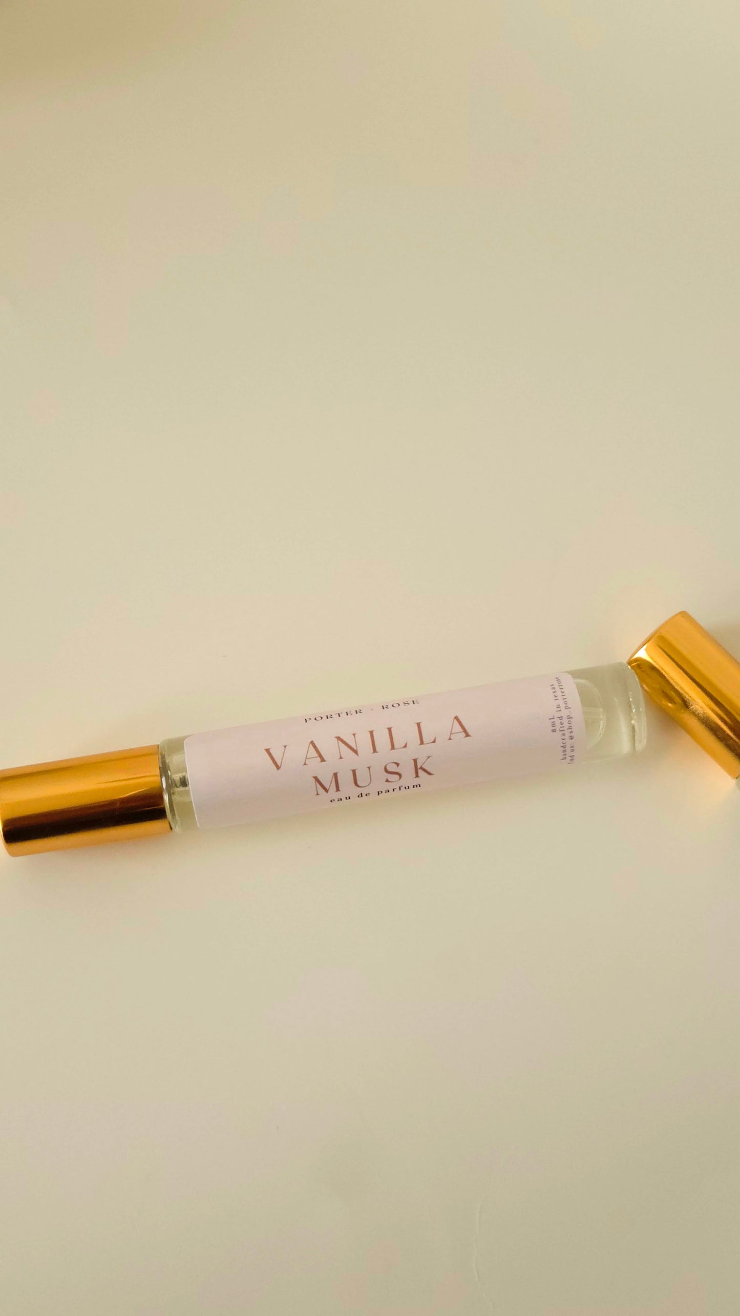 Vanilla Musk perfume bottle with gold cap on a beige background