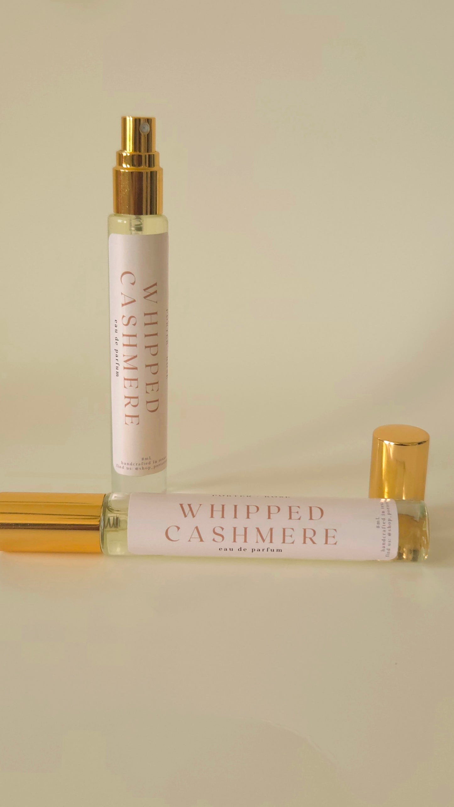 Two perfume bottles labeled 'Whipped Cashmere' on a beige background