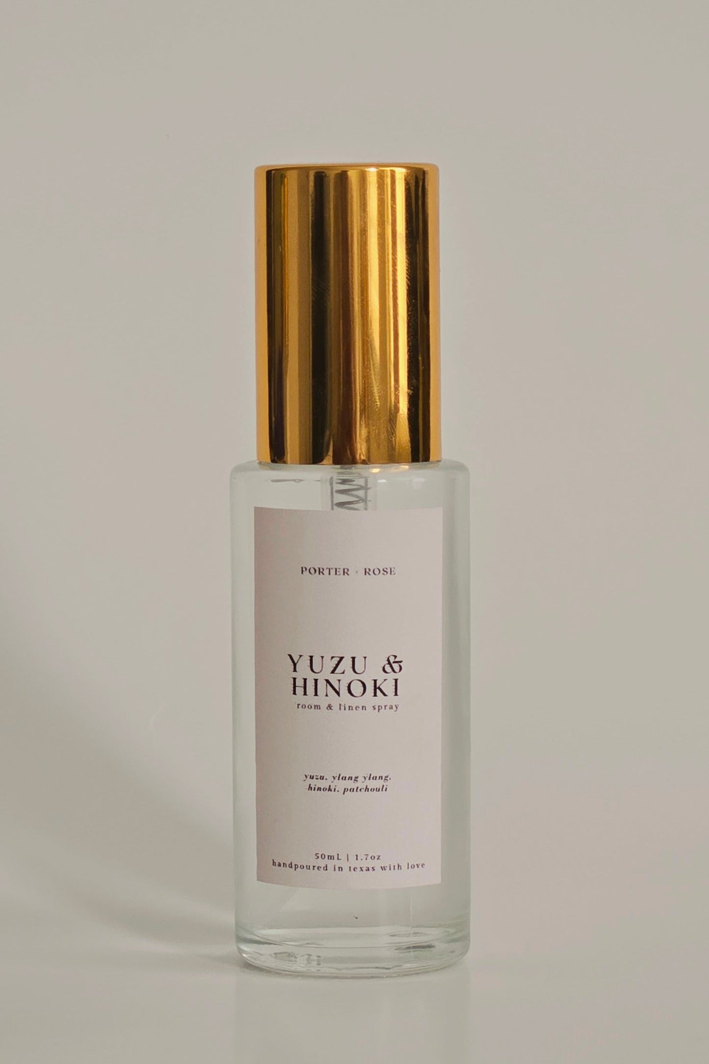 Clear glass bottle with gold cap on a gray background