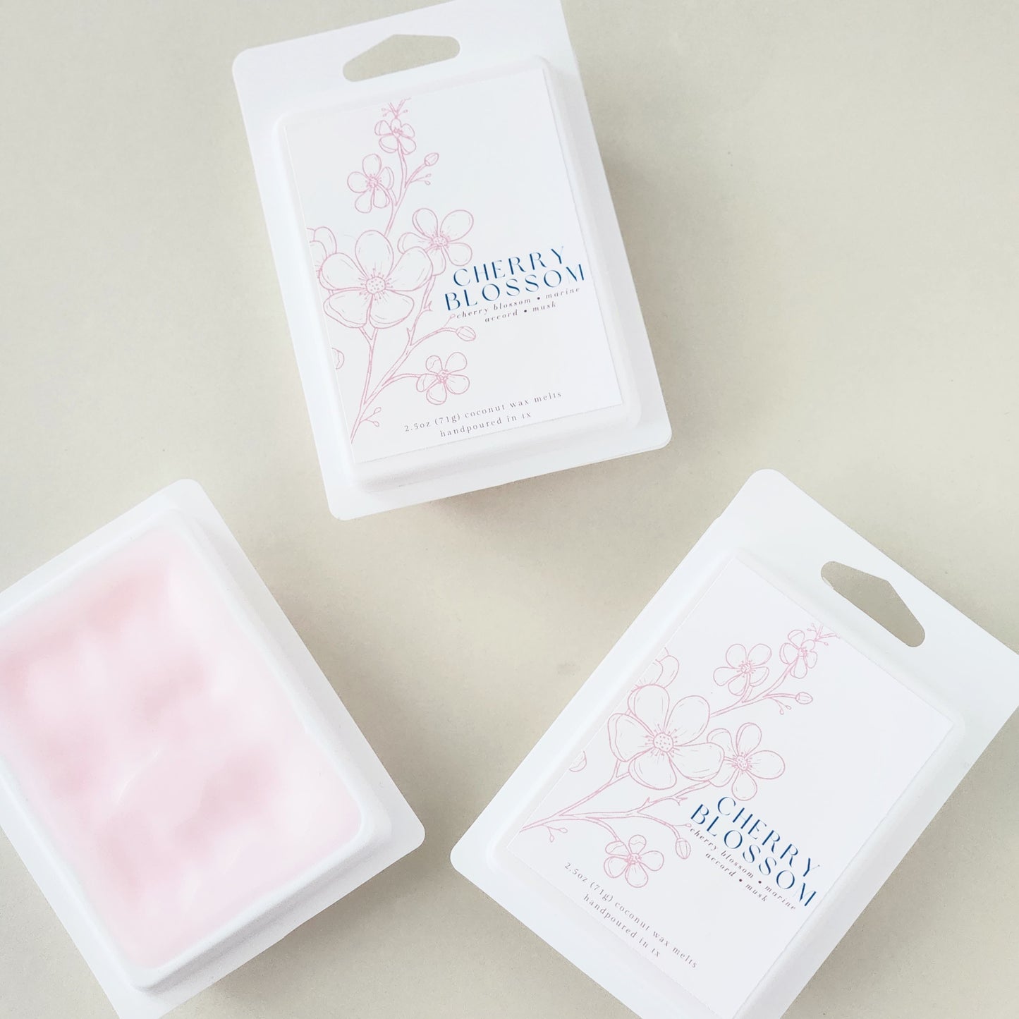 Six hand-poured cherry blossom wax melts packaged in a sleek white clamshell container. Limited edition spring fragrance for home.