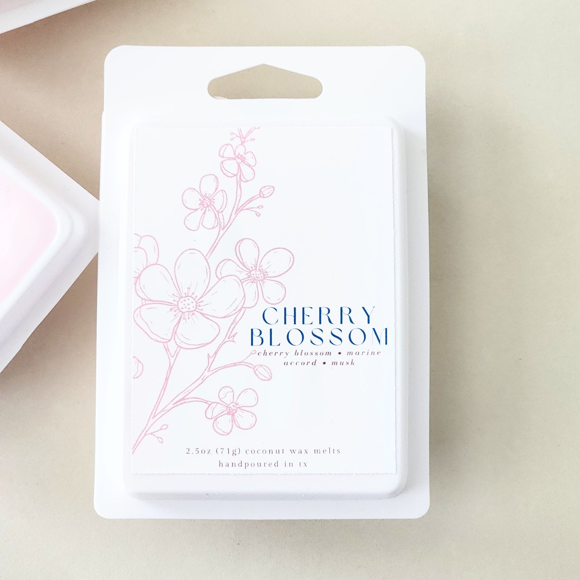 Six hand-poured cherry blossom wax melts packaged in a sleek white clamshell container. Limited edition spring fragrance for home.