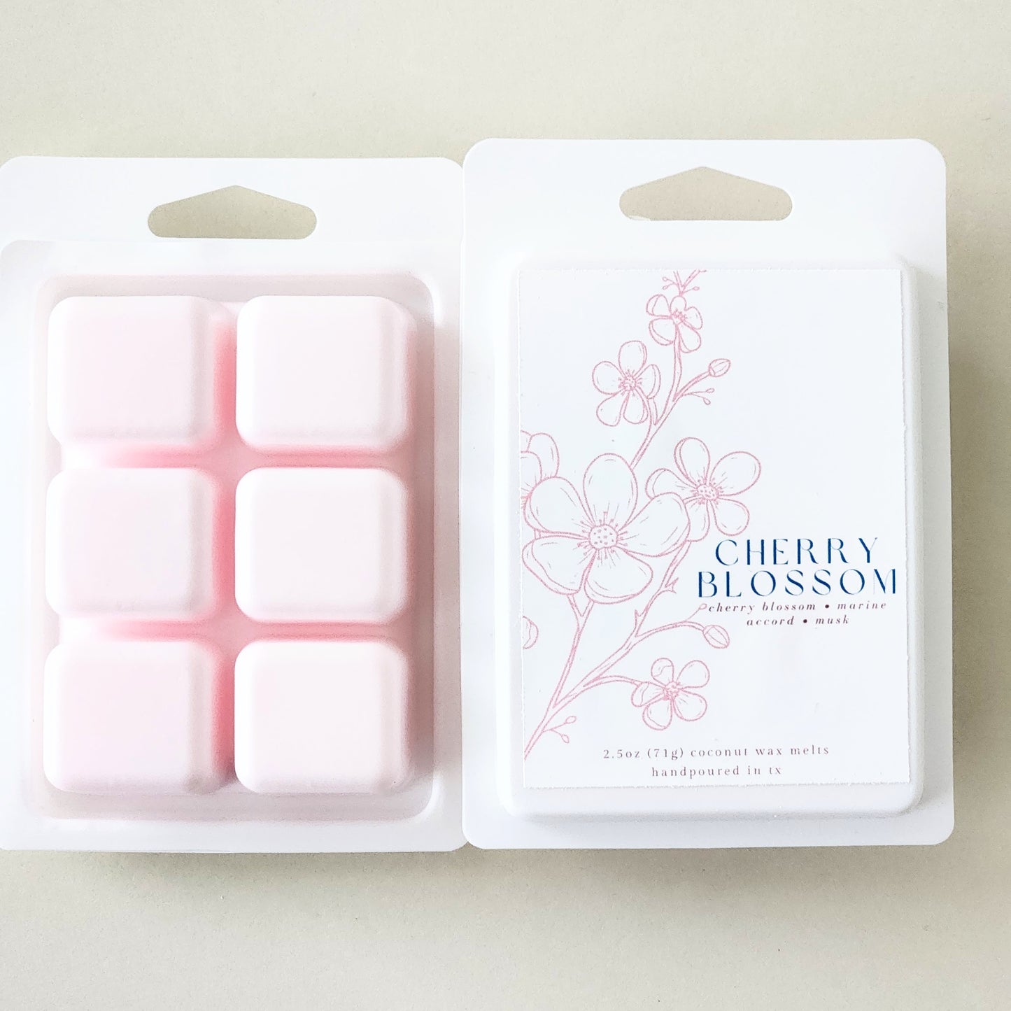 Six hand-poured cherry blossom wax melts packaged in a sleek white clamshell container. Limited edition spring fragrance for home.