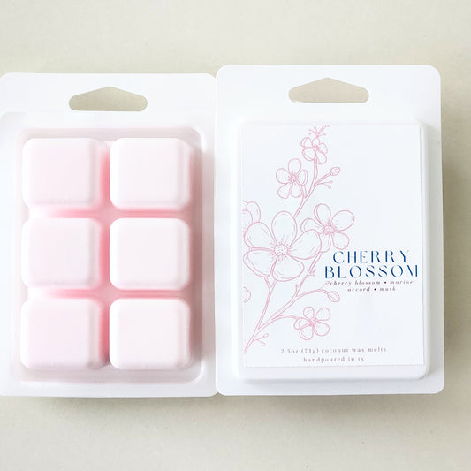 Six hand-poured cherry blossom wax melts packaged in a sleek white clamshell container. Limited edition spring fragrance for home.