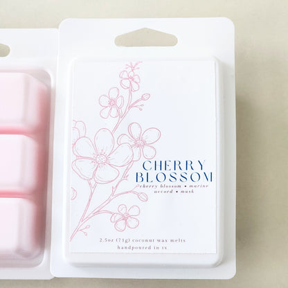 Six hand-poured cherry blossom wax melts packaged in a sleek white clamshell container. Limited edition spring fragrance for home.