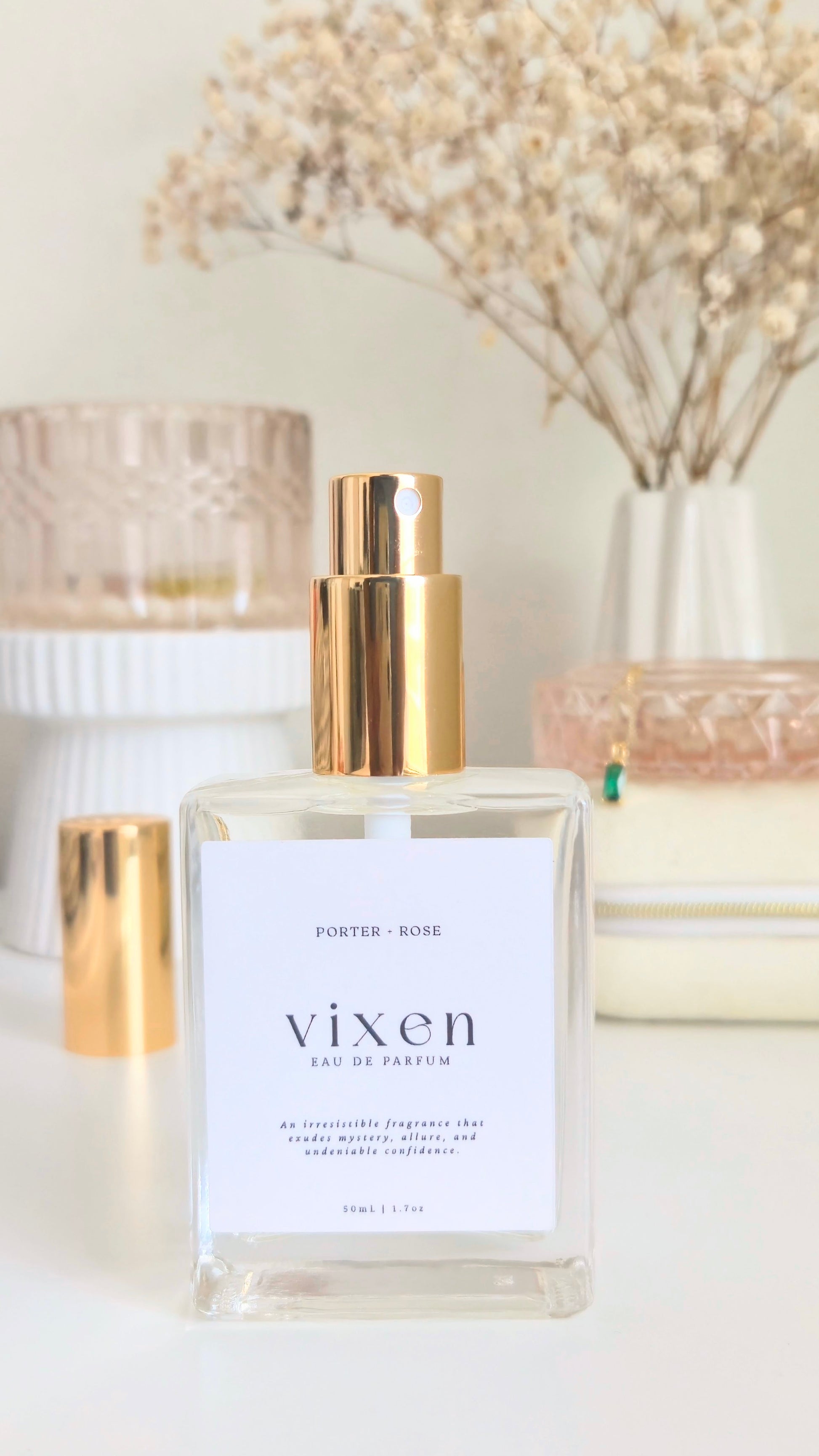 Vixen perfume bottle with gold cap on a white surface