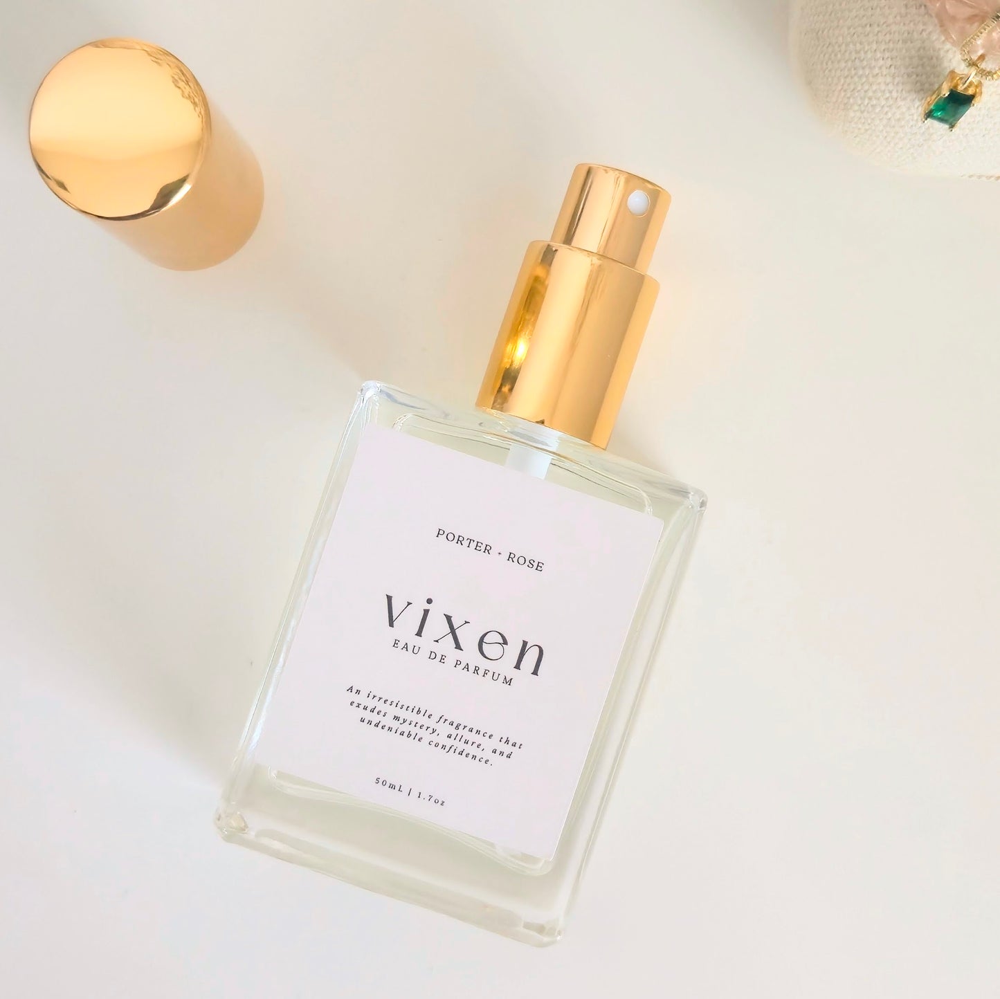 Perfume bottle labeled 'vixen' with gold cap on a light background