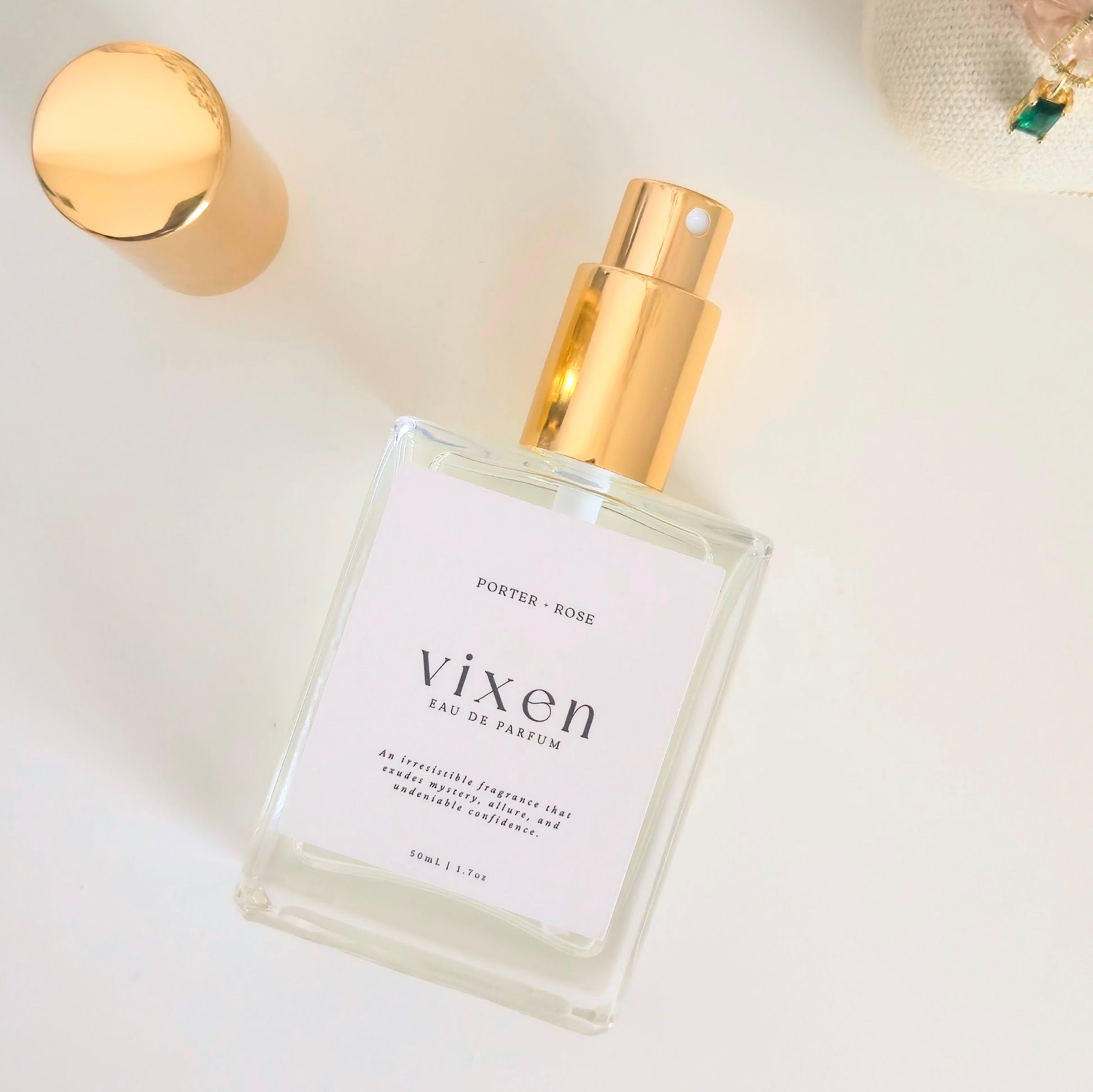 Perfume bottle labeled 'vixen' with gold cap on a light background