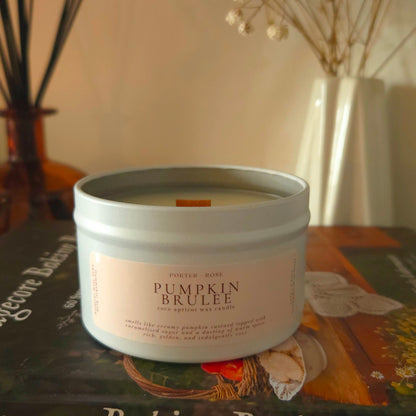 Cozy Pumpkin Brulee fall candle glowing on a decorated fireplace mantle with dried florals and cottage baking book