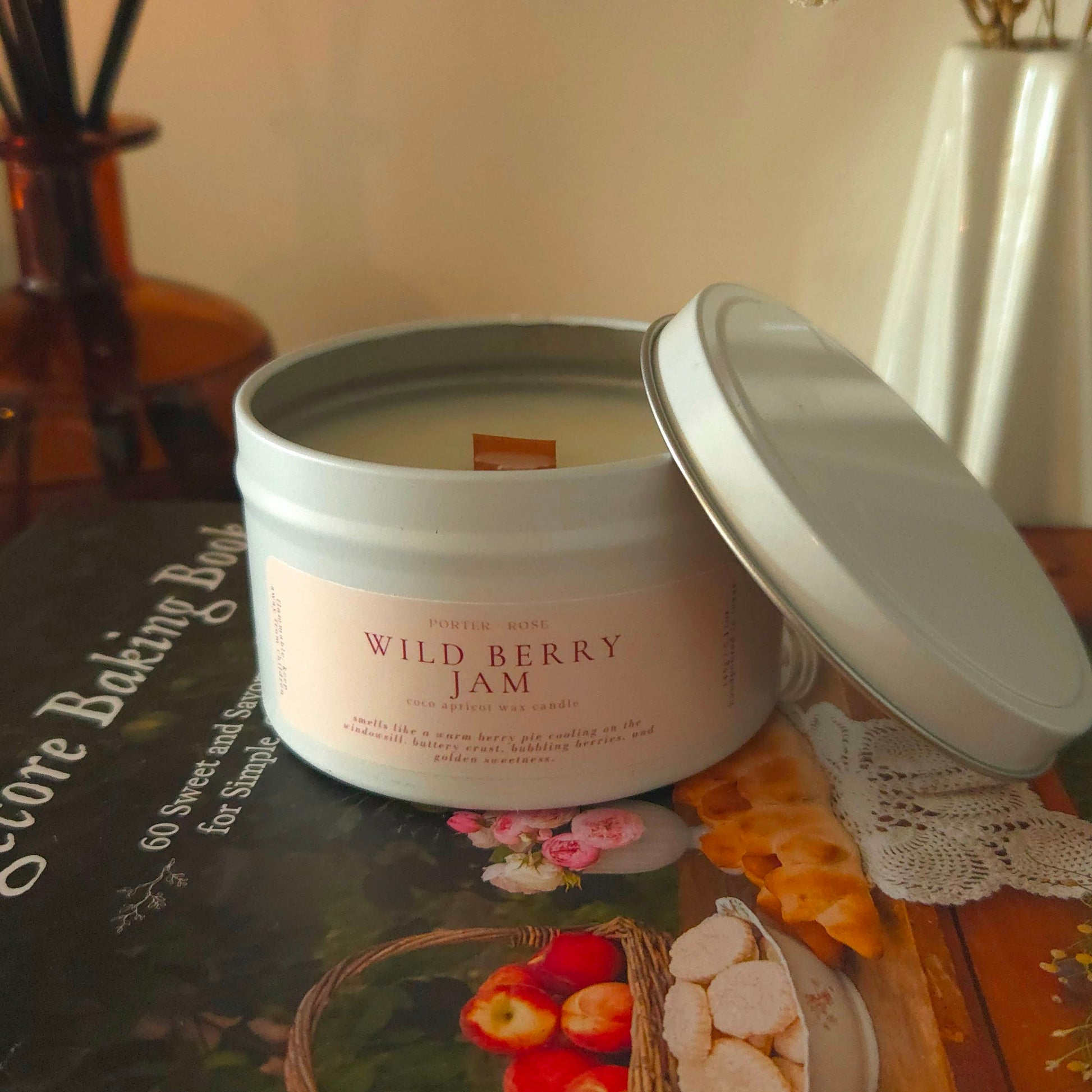 Wild Berry Jam dessert candle with wooden wick glowing on an autumn-decorated mantle