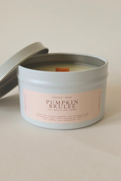 Pumpkin Brulee fall candle in a white tin jar with white lid, product photography on plain background.