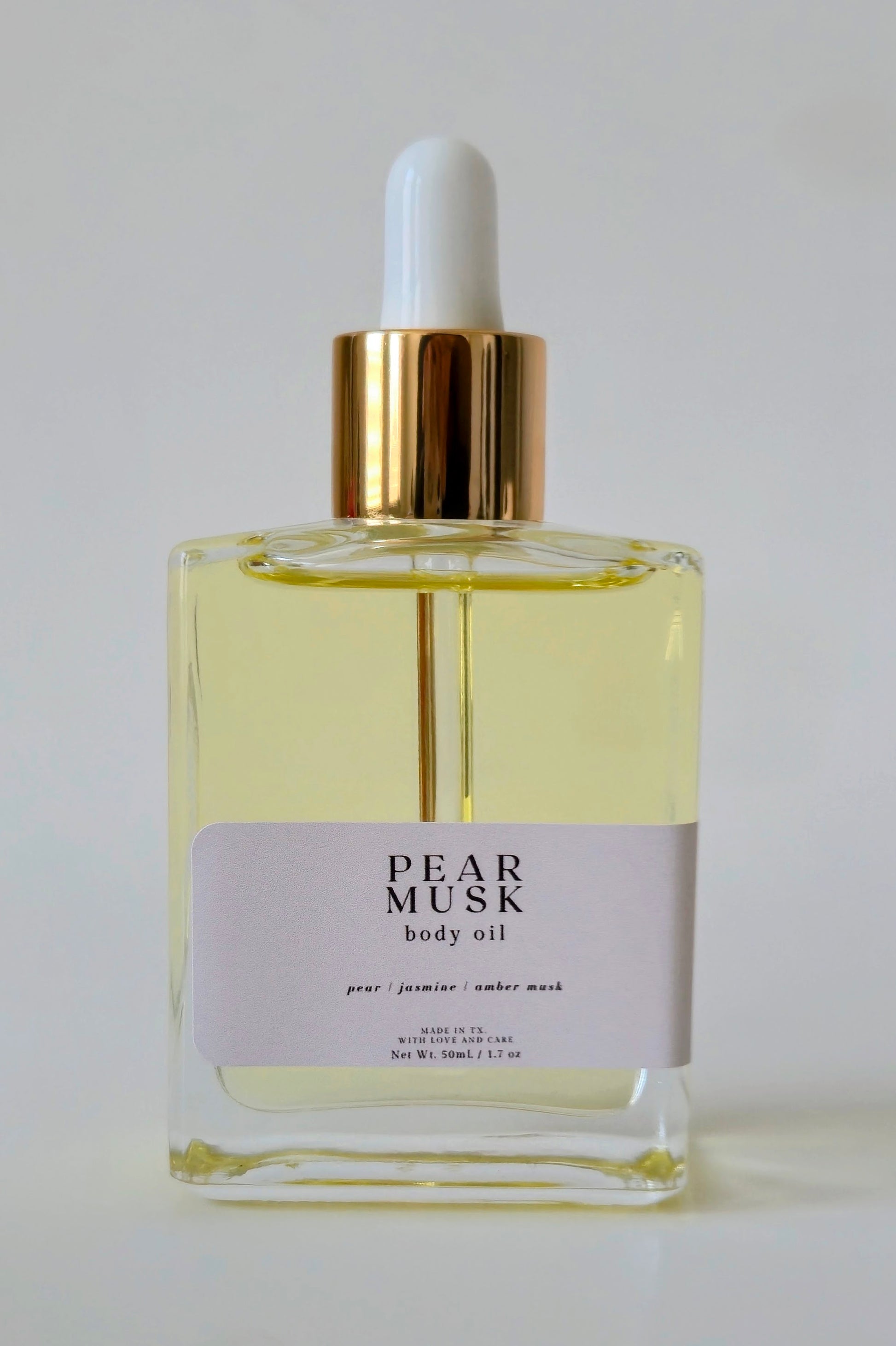 Pear Musk body oil bottle with dropper on a white background