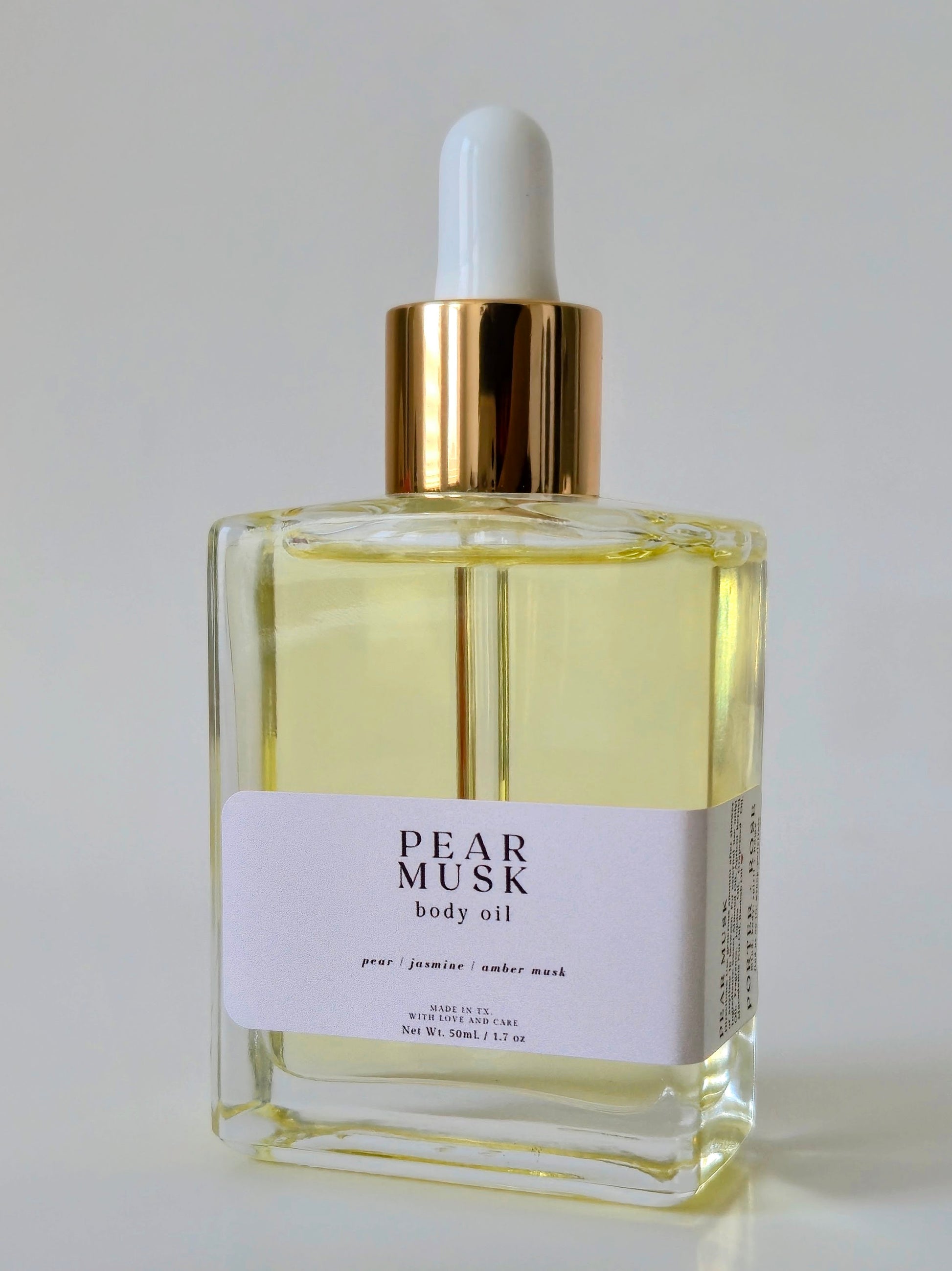 Bottle of Pear Musk body oil on a light gray background
