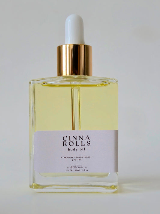 Bottle of Cinna Rolls body oil with a dropper on a white background