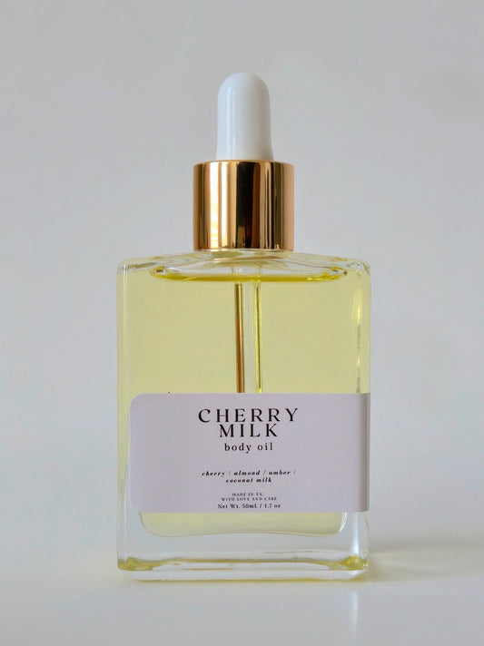 Bottle of Cherry Milk body oil with a dropper on a white background