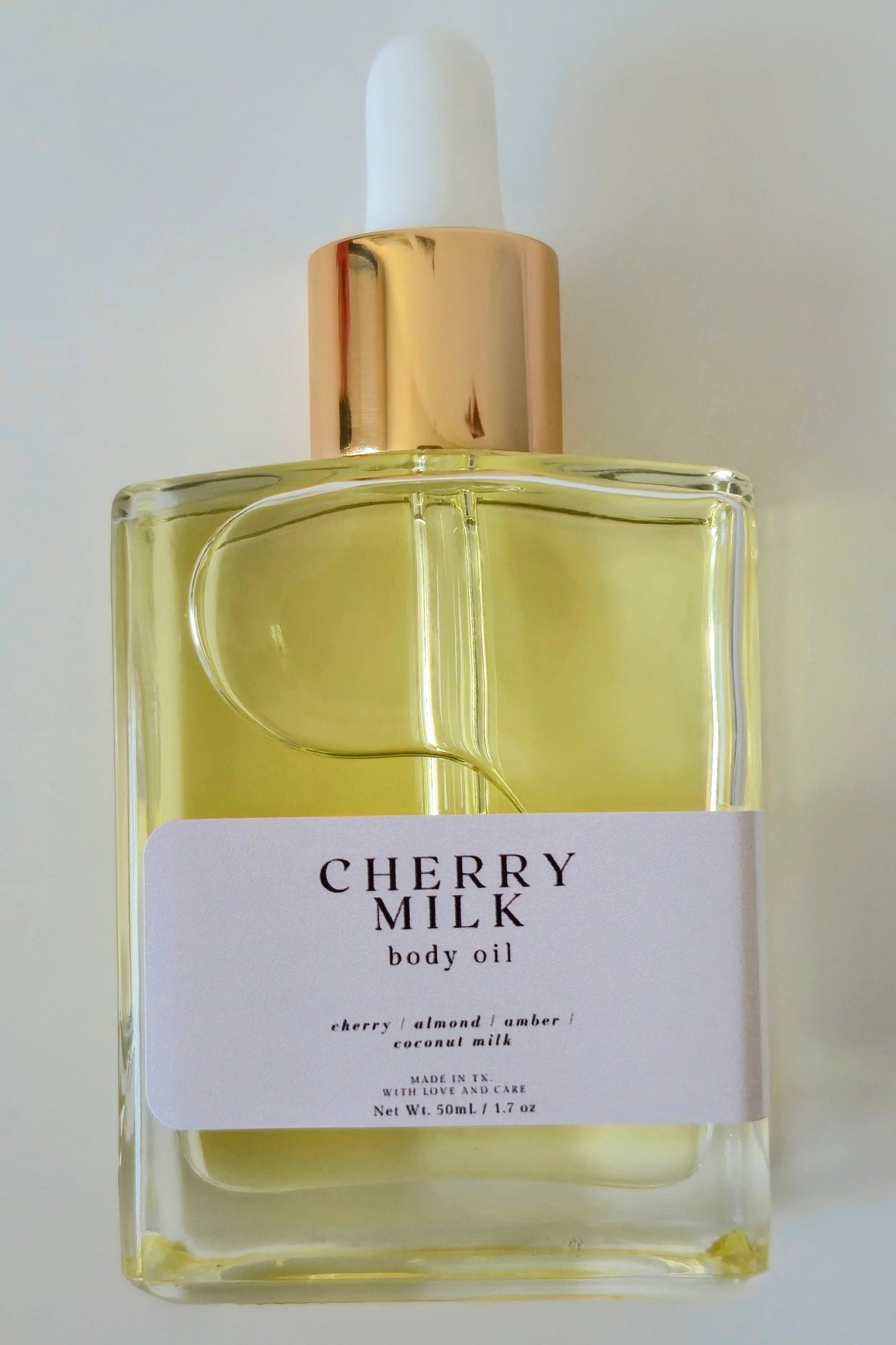 Cherry Milk body oil bottle with dropper on a white background