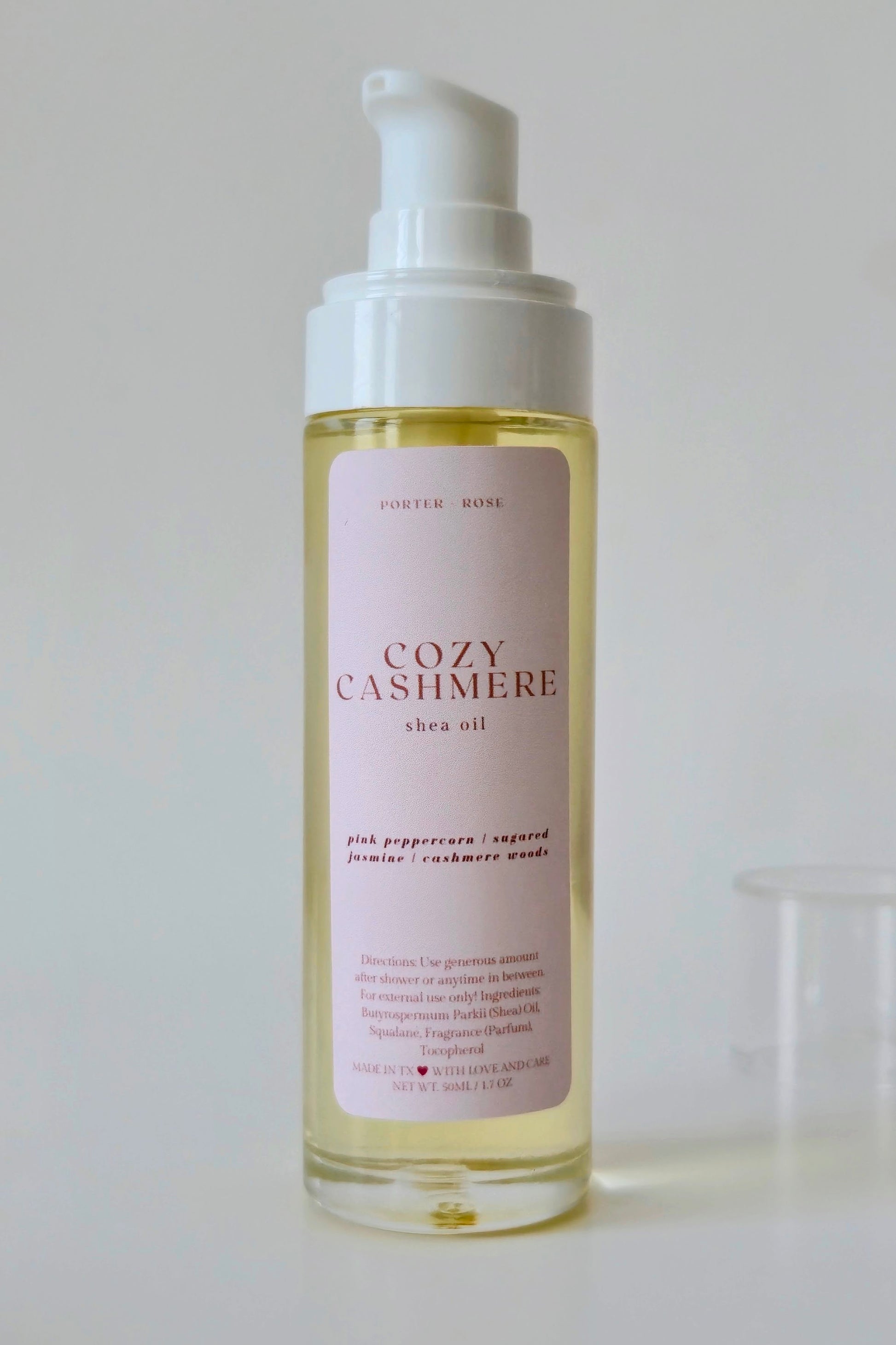 Bottle of Cozy Cashmere shea oil on a light background