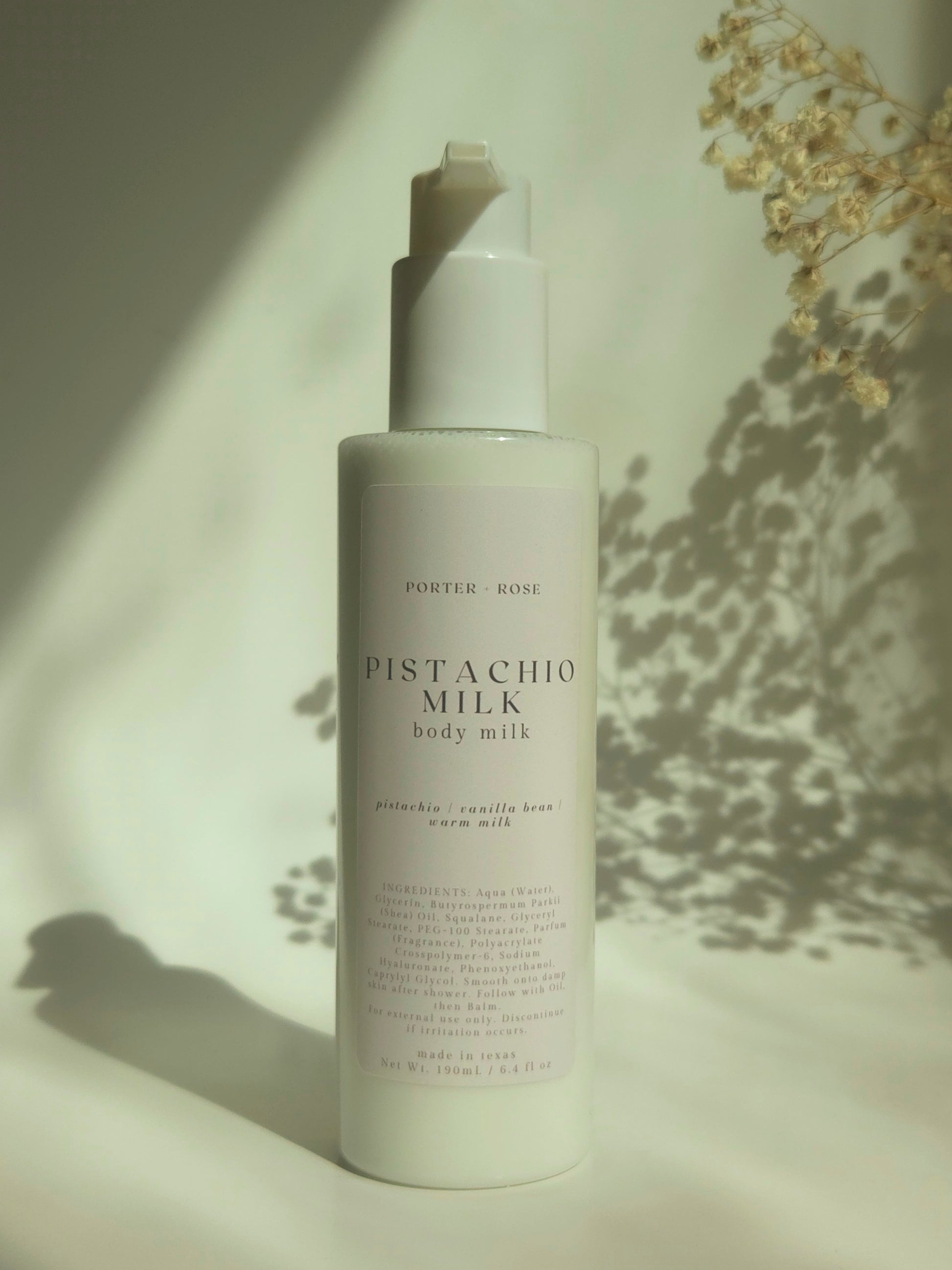 Pistachio Milk body milk bottle on a neutral background with soft shadows