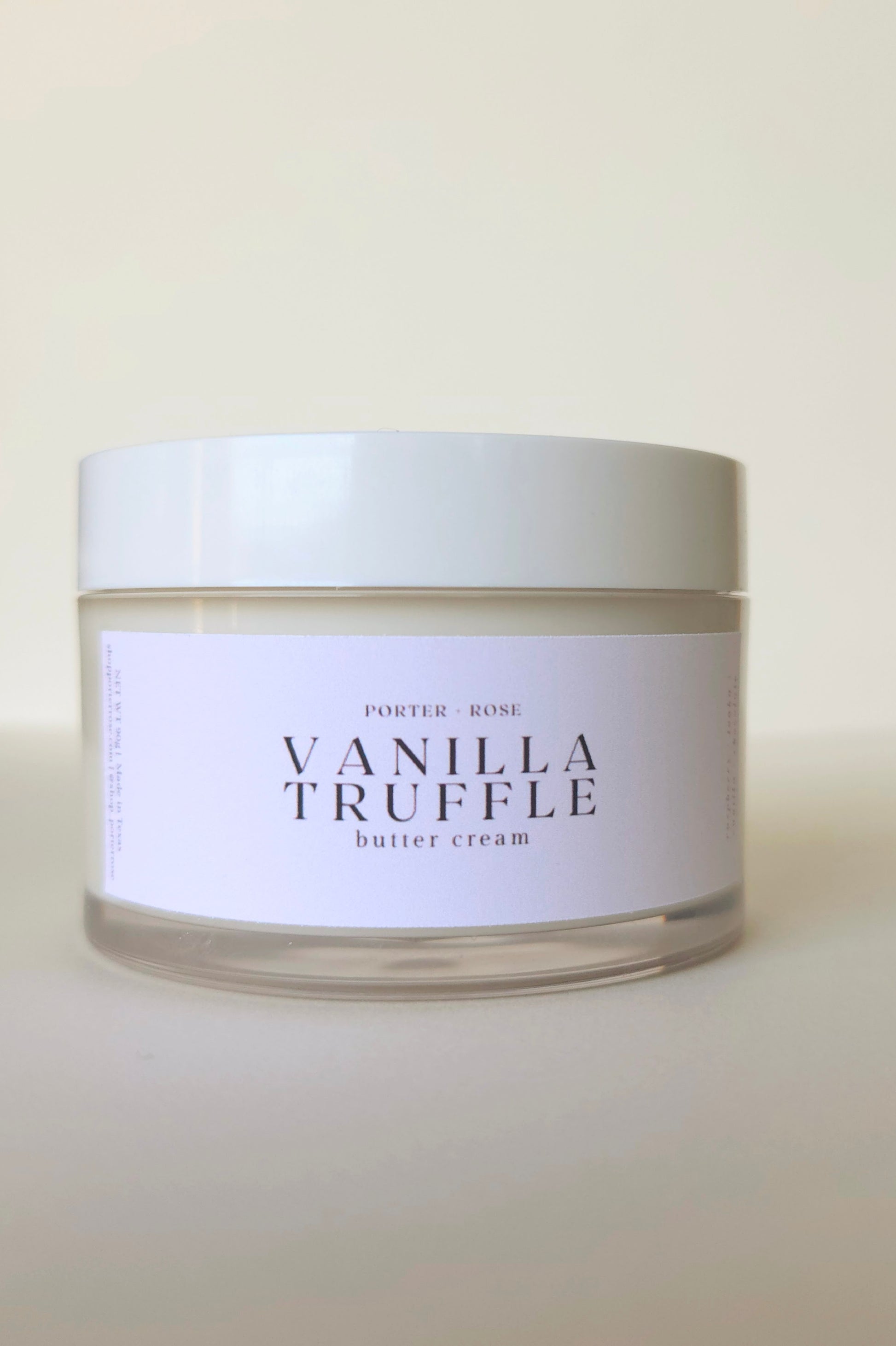 Jar of vanilla truffle butter cream with a white label on a beige background