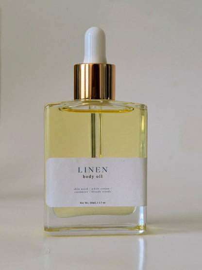 Bottle of Linen body oil with a dropper on a light background