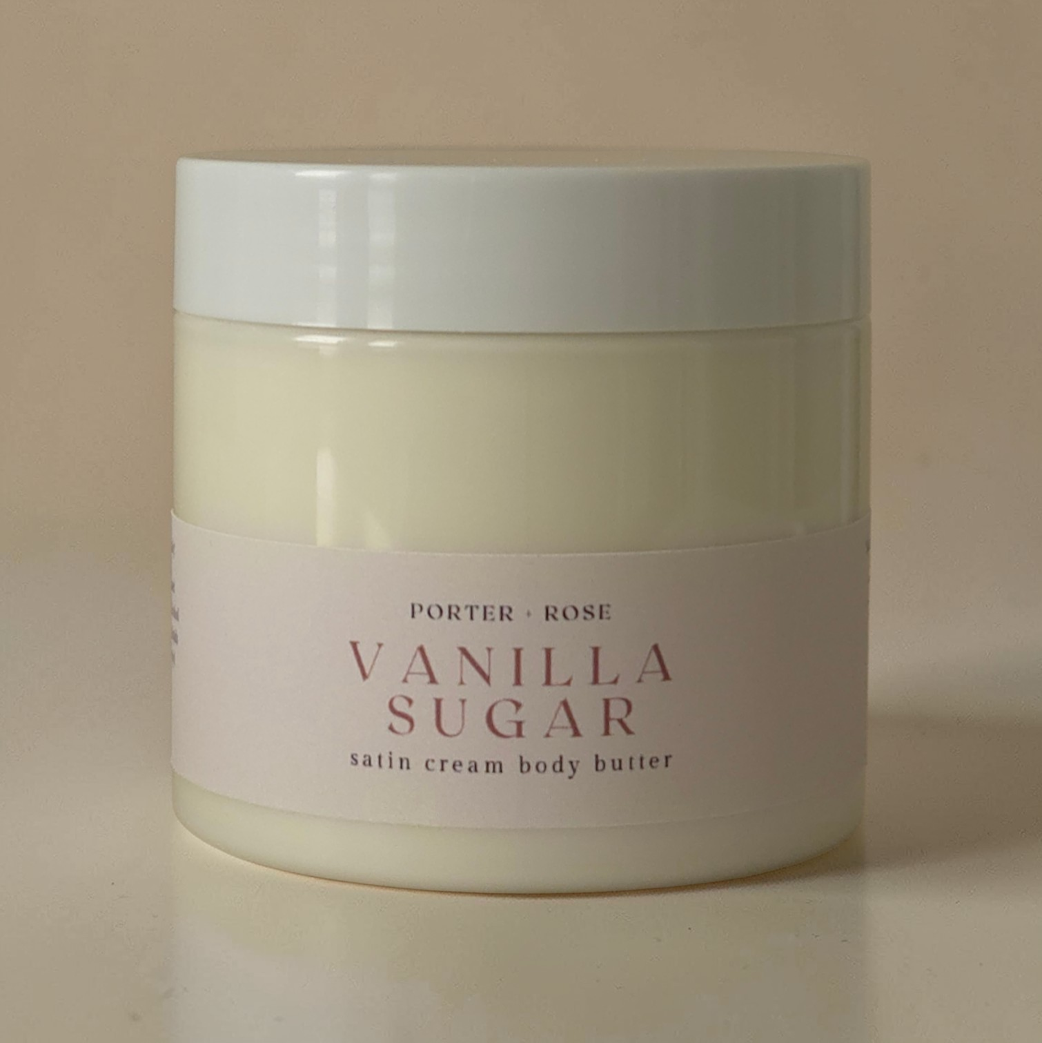 Jar of Porter & Rose Vanilla Sugar satin cream body butter on a beige background