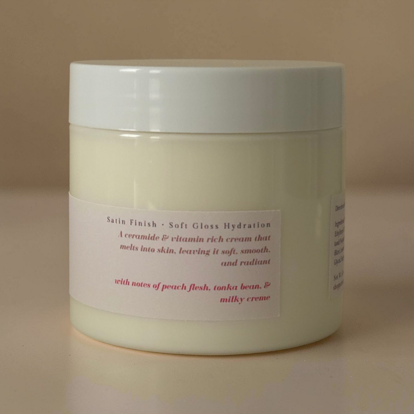 Jar of ceramide body cream with a label on a beige background