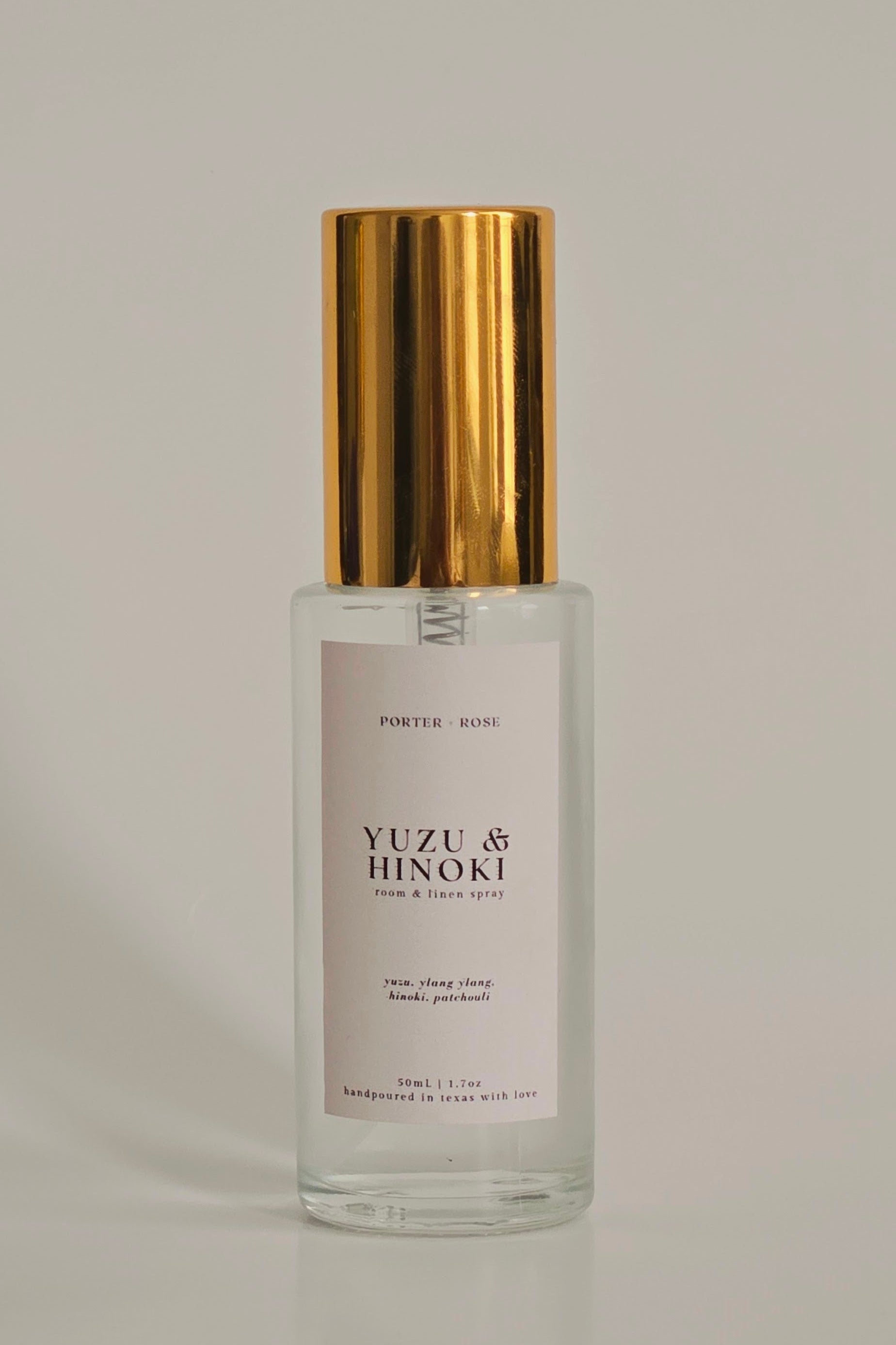 Clear glass bottle with gold cap on a gray background