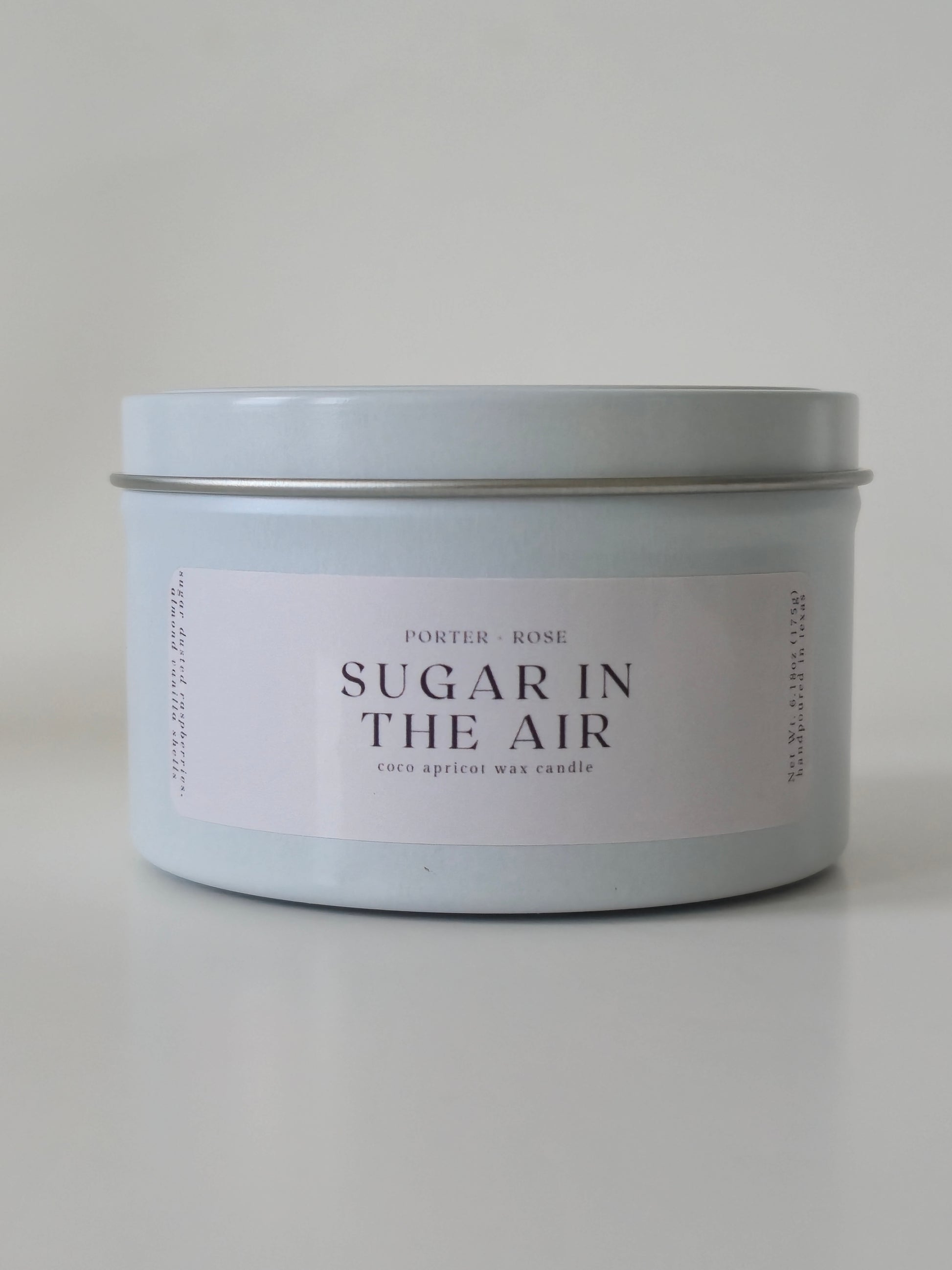 White Metal Tin 'Sugar in the Air' Candle on a light gray background