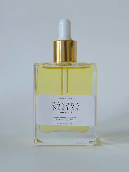 Bottle of Banana Nectar body oil with a white label on a light gray background