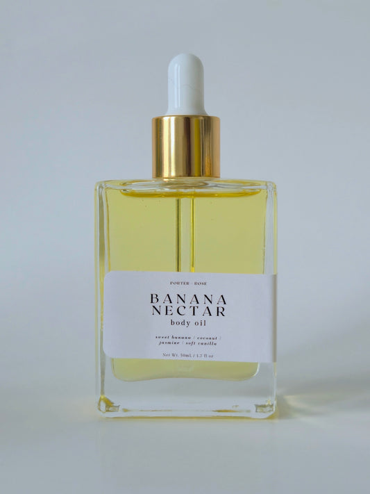 Bottle of Banana Nectar body oil with a white label on a light gray background