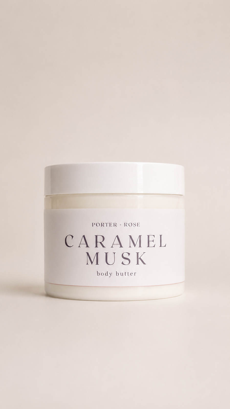 A white plastic jar of Porter Rose Caramel Musk body butter, featuring a minimalist white label with black text, set against a solid light beige background.