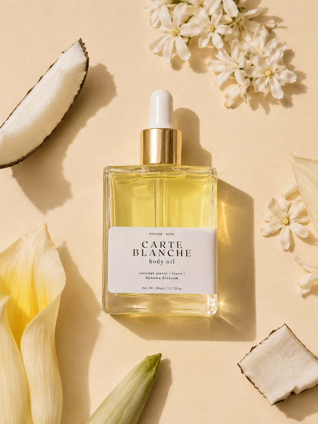 Carte Blanche body oil bottle with flowers and coconut on a beige background