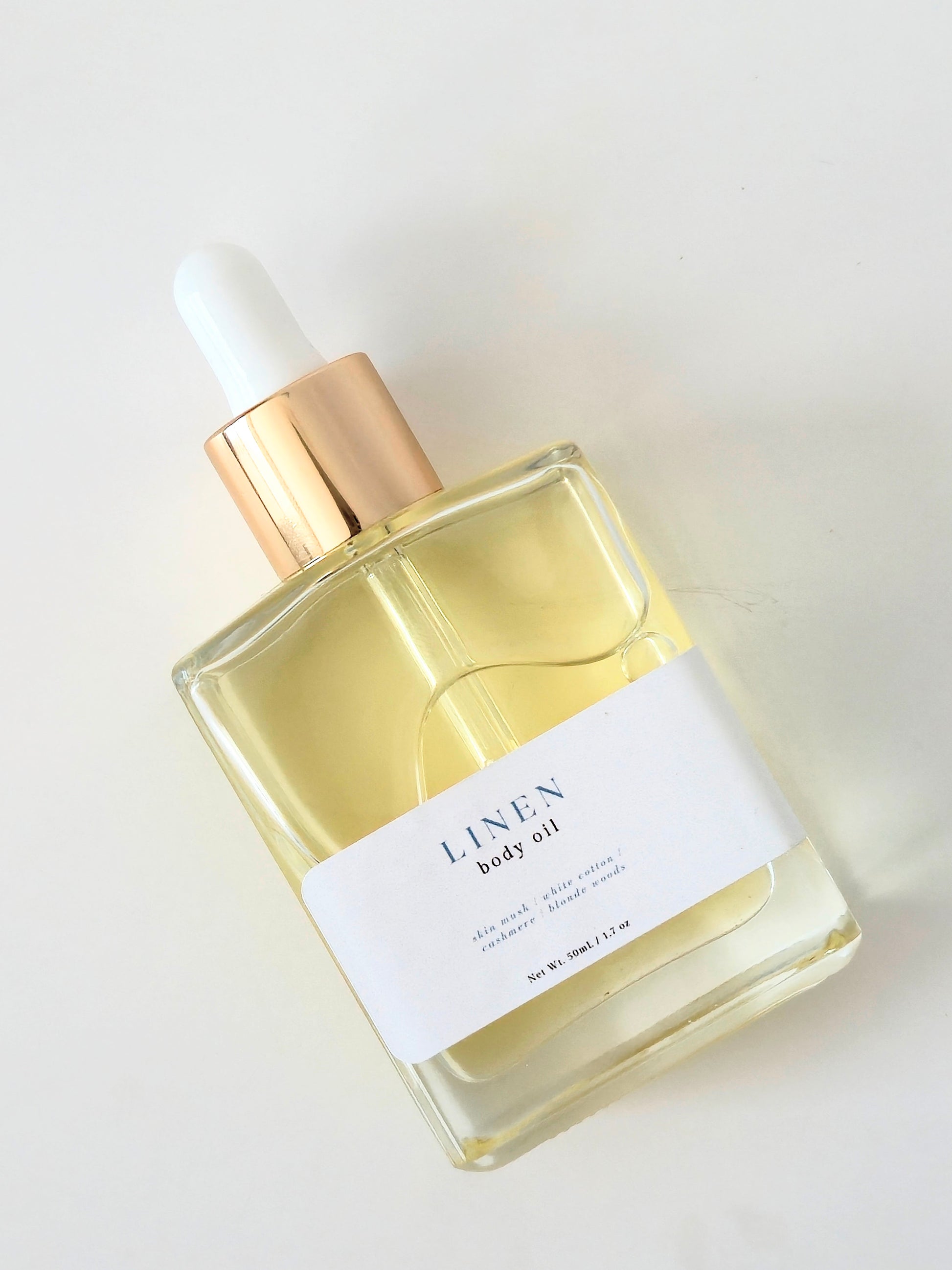 Bottle of Linen body oil with dropper on a white background