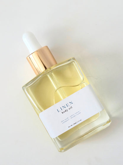 Bottle of Linen body oil with dropper on a white background