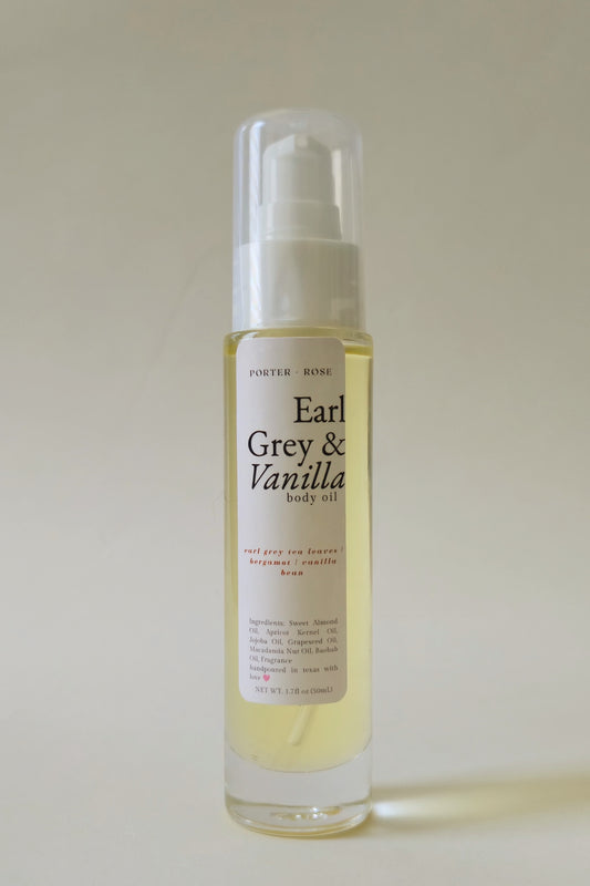 A clear pump bottle of Porter Rose Earl Grey & Vanilla body oil containing a pale yellow liquid, set against a neutral beige background.