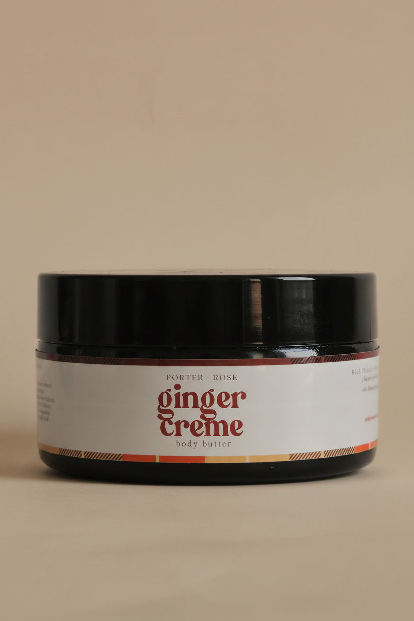 A black jar of Ginger Creme body butter with a white label, shown against a plain light gray background.