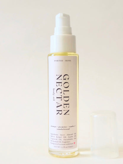 A bottle of Porter Rose Golden Nectar body oil with a white pump dispenser and a small clear cap placed beside it on a light beige background.