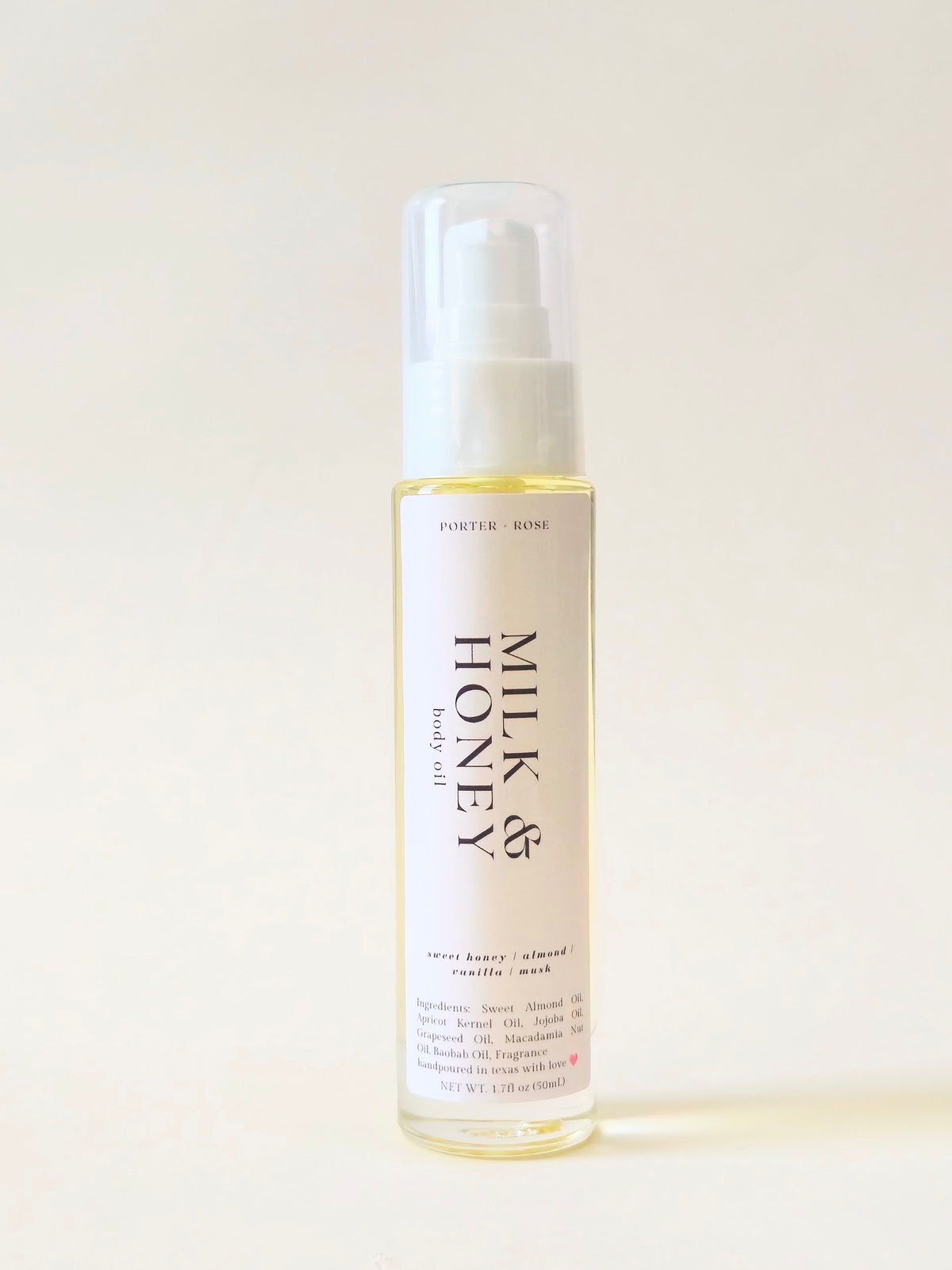 A clear bottle of Porter Rose Milk & Honey body oil with a white pump dispenser, set against a plain off-white background.