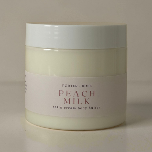 Jar of Porter & Rose Peach Milk satin cream body butter on a beige background