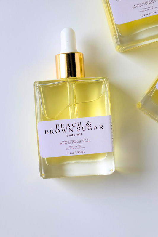 Body oil bottle labeled 'Peach & Brown Sugar' on a white background