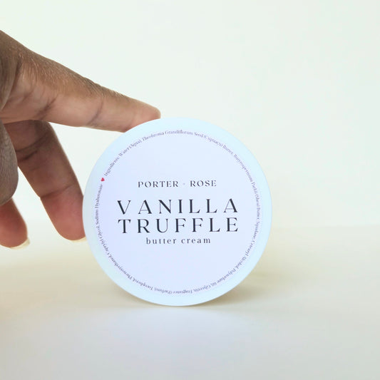 Hand holding a container of Porter & Rose Vanilla Truffle body butter cream against a white background