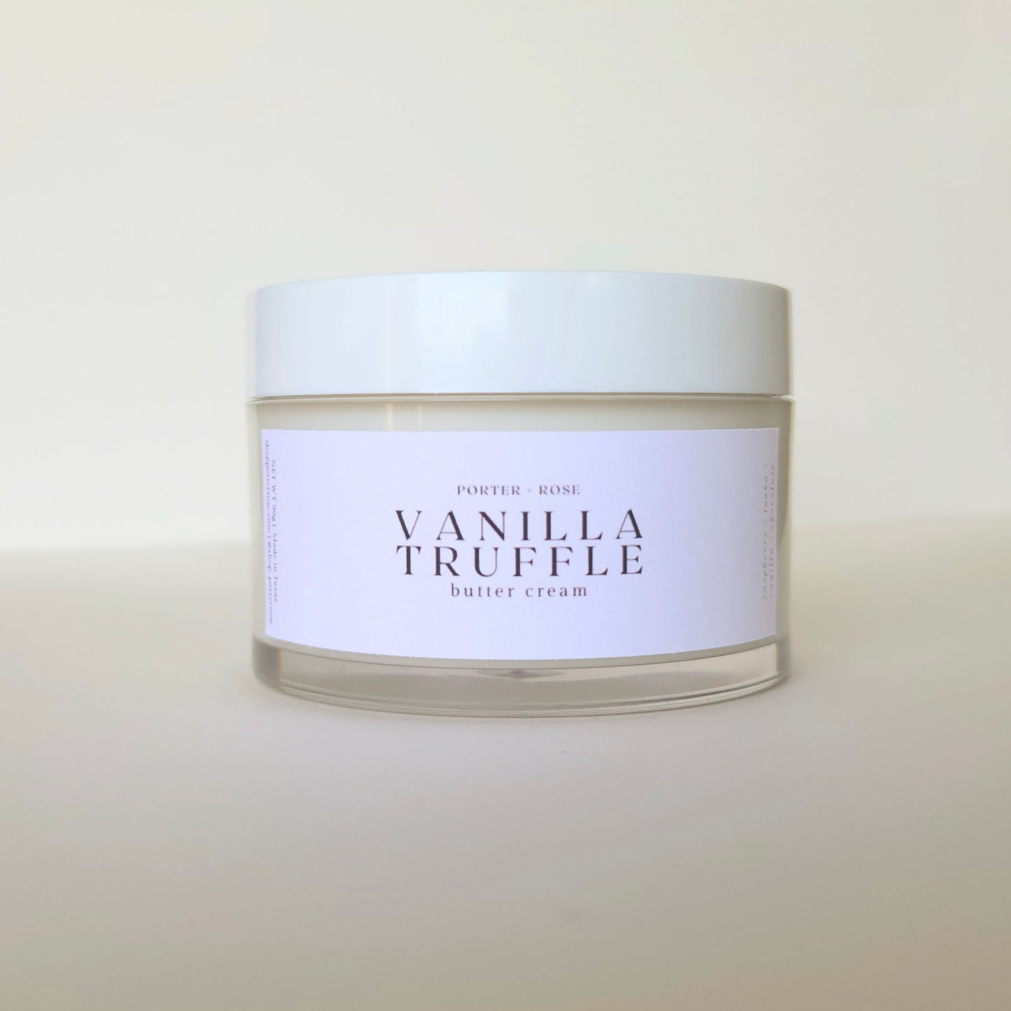 Jar of vanilla truffle body butter cream with a white label on a light background