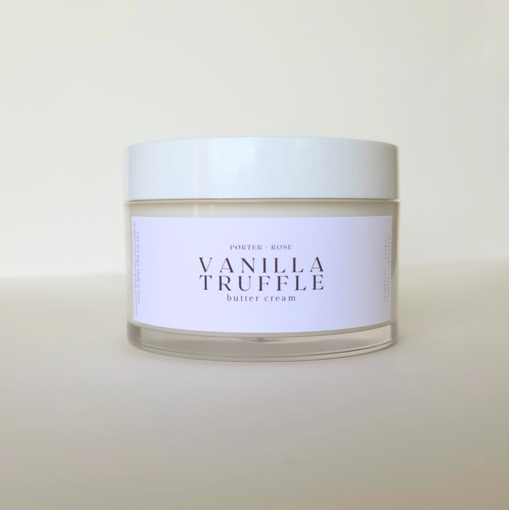 Jar of vanilla truffle body butter cream with a white label on a light background